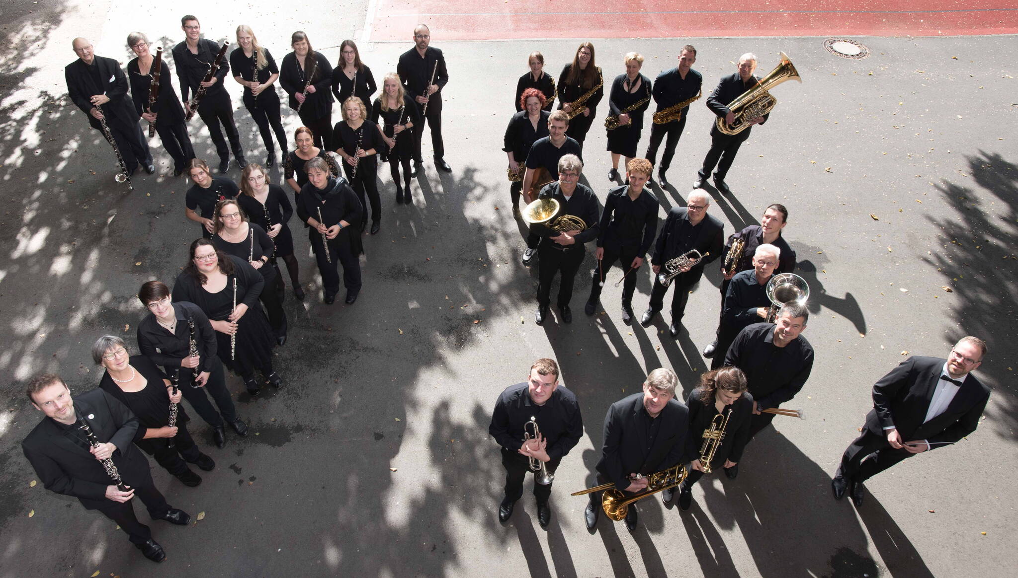 Mitglieder des 3 Sparren Orchesters formen in schwarzer Konzert-Kleidung eine "75.". Fotografiert aus der Vogelperspektive